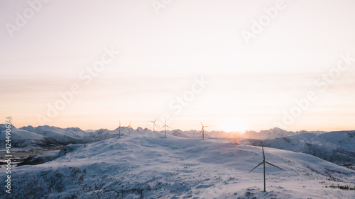 Windmills on snowy mountains at shiny sunset © BullRun