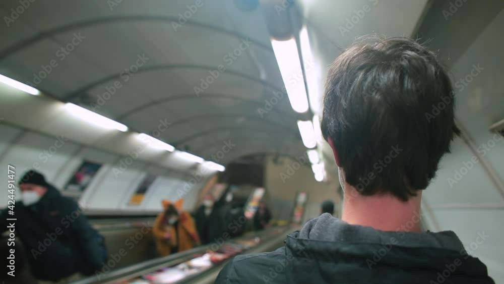 Using the phone near the ear. It automatically descends to the level. The pedestrian overtakes. A masked man descends an escalator into subway tunnel. Using the phone near the ear. It automatically descends to the level. The pedestrian overtakes. A masked man descends an escalator into subway tunnel.