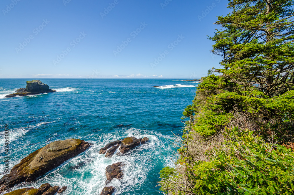 Ocean view with mountains, small island, blue sky and white clouds at summer day.