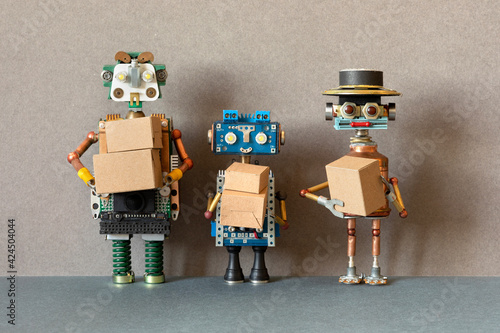 Three happy robots are holding cardboard boxes. Automation of the order delivery process using robots