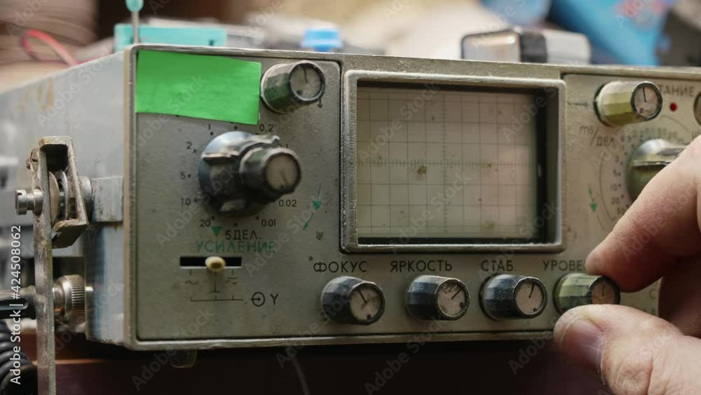 Man's hand turns knobs on old machine with a display. Old technologies in modern world Man's hand turns knobs on old machine with a display. Old technologies in modern world