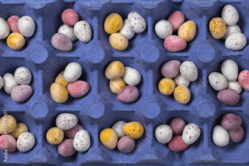 Wallpaper Mural Small mixed colourful eggs in blue egg tray. Easter background. Top view Torontodigital.ca