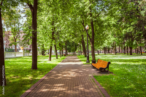 Walkway, bench and lantern in the European, city park. © irina1791