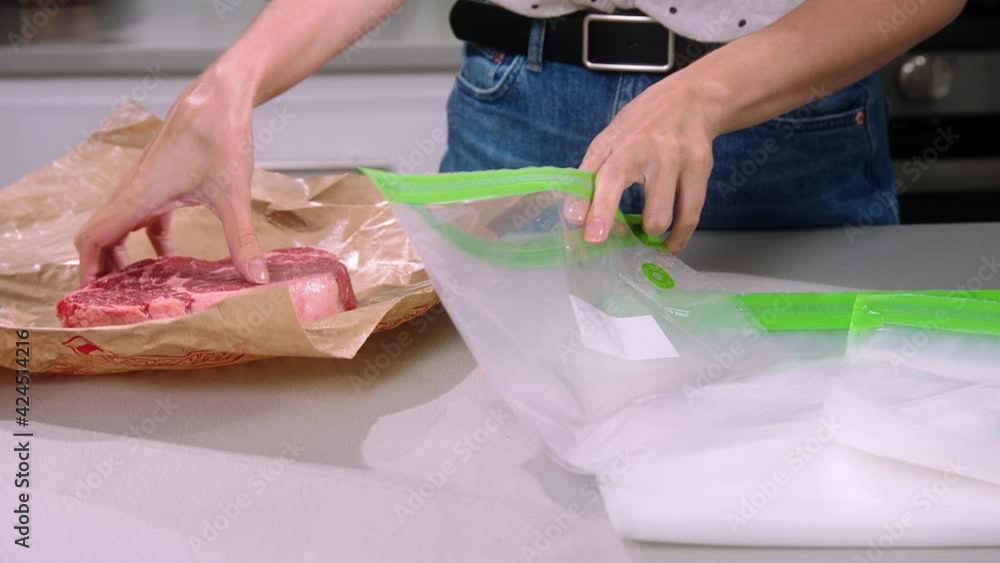 Girl packing the meat, meat in vacuum packaging, meat vacuuming, Vacuum-packing of a fresh spiced beef shank, Girl Vacuum Packs Pork Chops Girl packing the meat, meat in vacuum packaging, meat vacuuming, Vacuum-packing of a fresh spiced beef shank, Girl Vacuum Packs Pork Chops