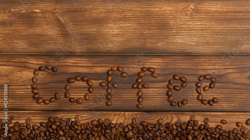 The inscription coffee from beans on a wooden background. Copy space. Flat lay