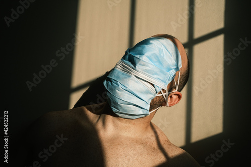desperate person with mask at home due to the closure of the pandemic in times of covid. quarantine