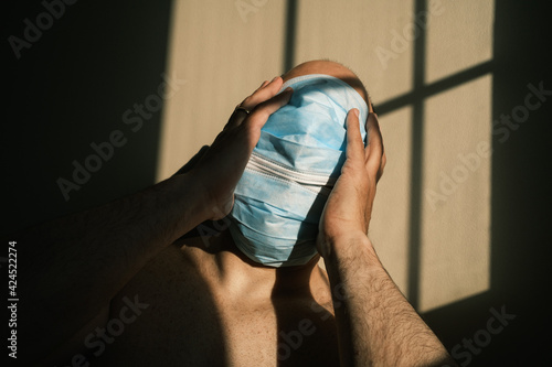desperate person with mask at home due to the closure of the pandemic in times of covid. quarantine