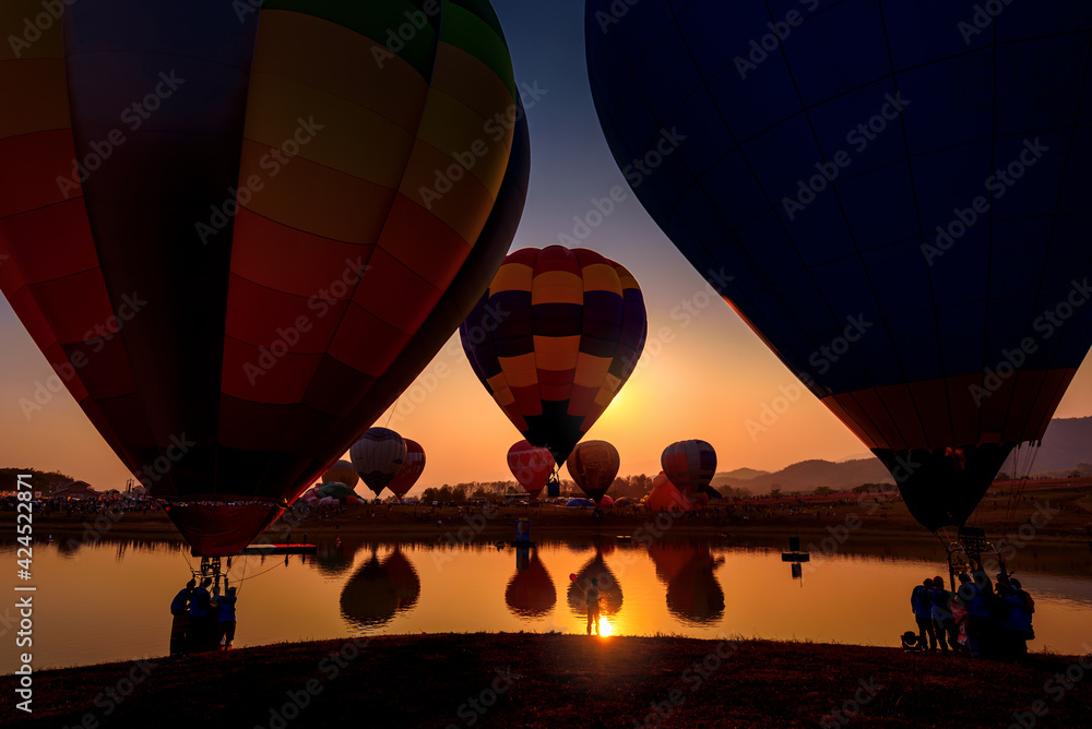 Obraz premium Silhouette hot air balloon over mountains lake in sunset sky