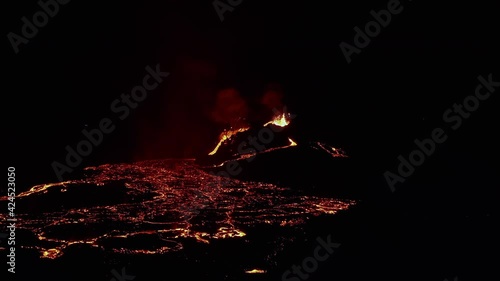 Aerial view of volcano craters and glowing magma, night time, in Iceland - rising, drone shot photo