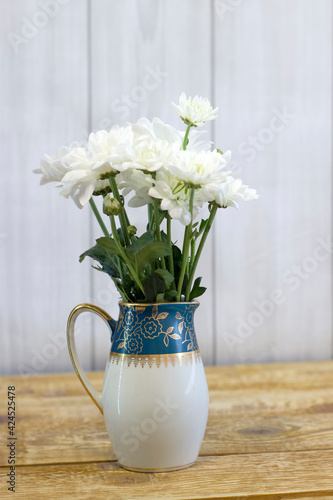 Wallpaper Mural Fresh white flowers in green milk jug on light wooden background close up Torontodigital.ca