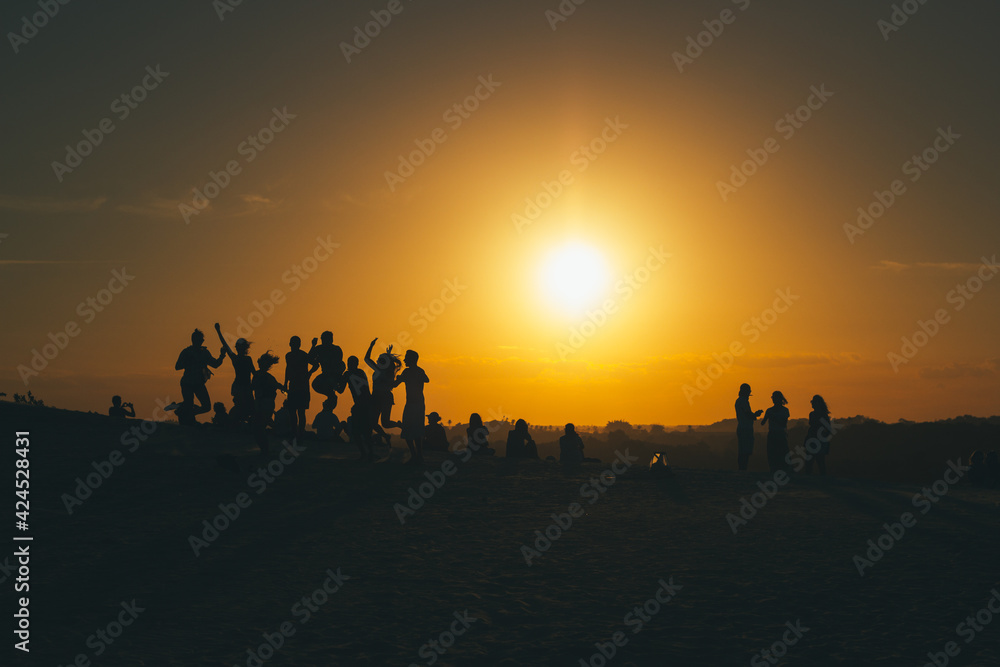 silhouettes of happy people at sunset
