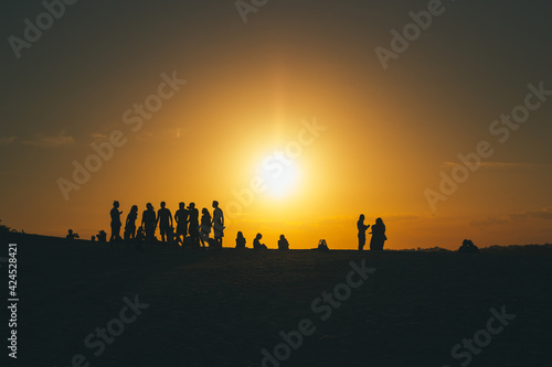 group of people walking on sunset