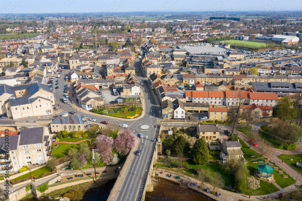 Aerial photo of the beautiful village of Wetherby, Leeds, West Yorkshire in the UK showing the main street along side the river and the main bridge going into the town