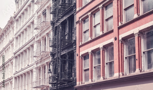Old buildings with iron fire escapes, color toning applied, New York City, USA.