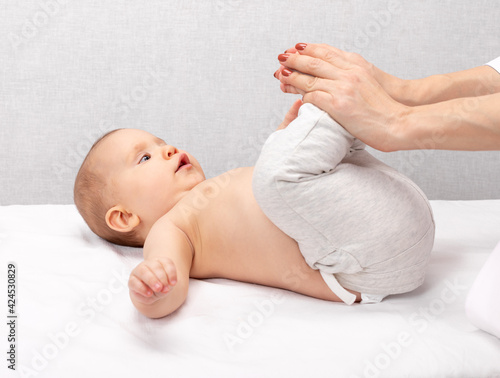 Foto Little baby receiving osteopathic treatment of her leg to prevent hip dysplasia