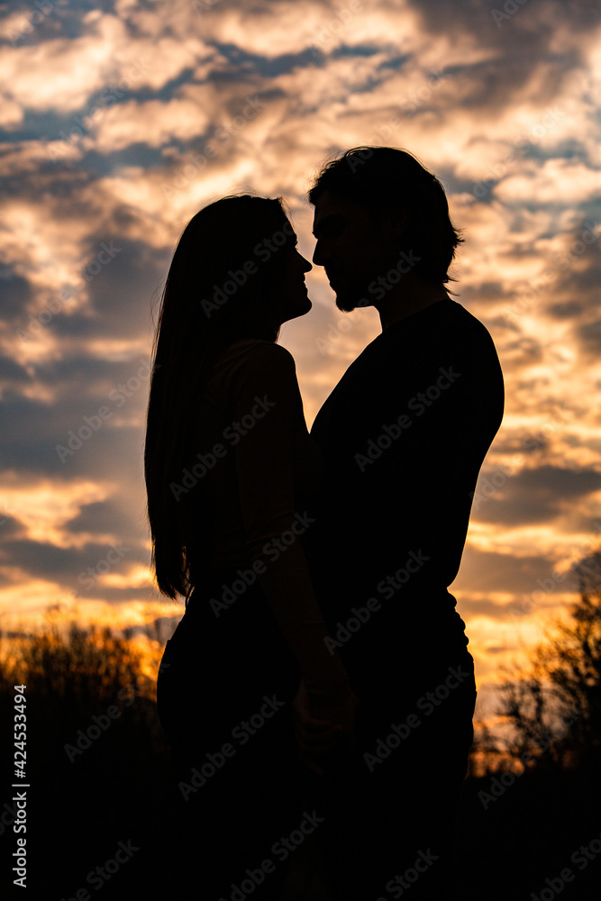 Silhouette of romantic couple in love, man and women in sunset sky. Romantic of relationships between couple love in the garden