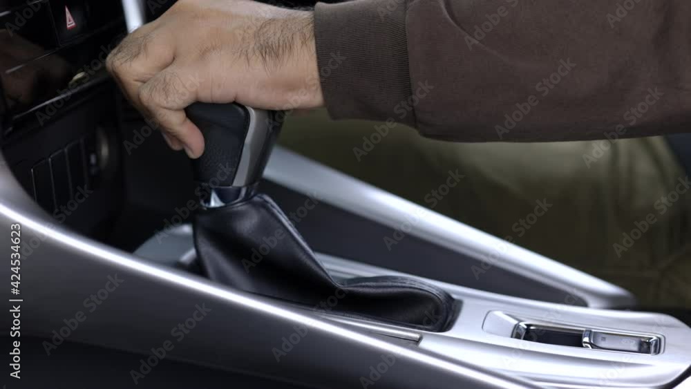 Young man finished the driving car he hand control the stick shift