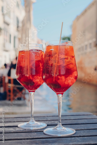 Two glasses of Spritz Veneziano cocktail served near the Venetian canal.  Popular italian summer aperitif drink.