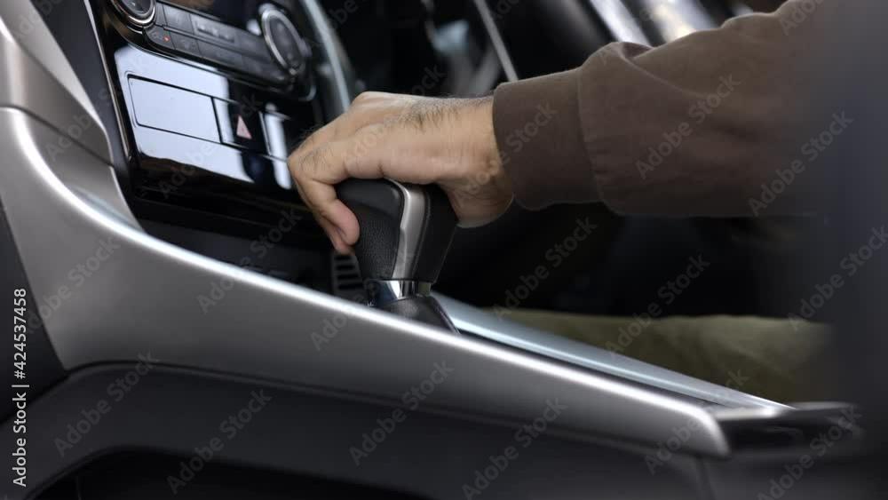 Young men getting new car and his hand control the stick shift transmission in luxury car. Male hand changing gear driving car. Young men getting new car and his hand control the stick shift transmission in luxury car. Male hand changing gear driving car.