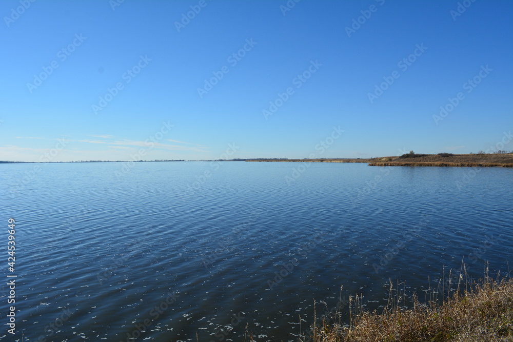 Blue lake disappears into the blue horizon of the sky