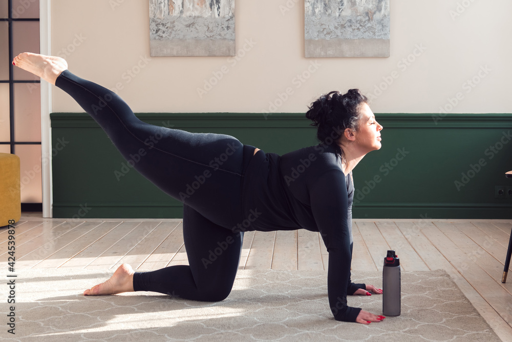 Fototapeta premium plus size woman doing pilates yoga stretching exercise at home