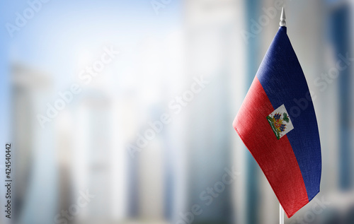 A small flag of Haiti on the background of a blurred background