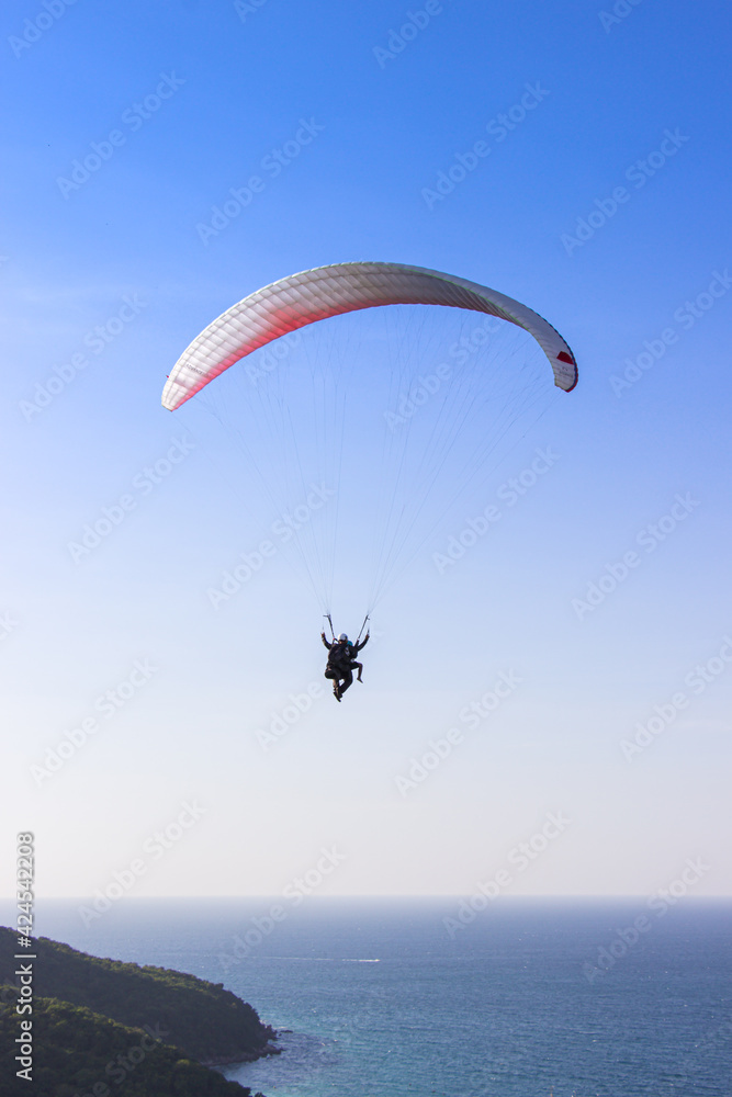 Paraglider flying over lush green mountains from view point on Koh Larn island in Pattaya, Chonburi Thailand. Paraglider flying over lush green mountains from view point on Koh Larn island in Pattaya, Chonburi Thailand.