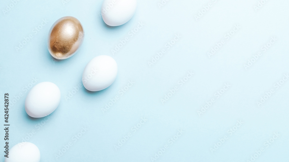 Easter luxury. Golden, white colour egg on pastel blue background in Happy Easter decoration. Flat lay, top view. Easter luxury. Golden, white colour egg on pastel blue background in Happy Easter decoration. Flat lay, top view.