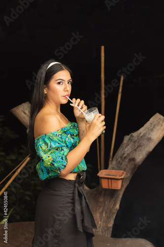 Outdoor portrait of beautiful young hispanic woman with long bla photo