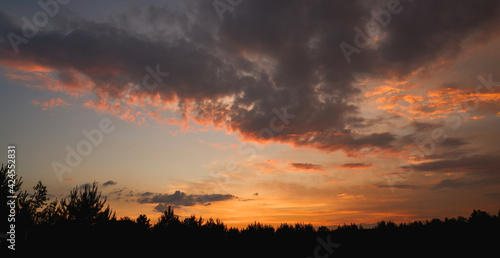 The sky at sunset before bad weather. Low red sunlight illuminates thunderclouds. © Trik