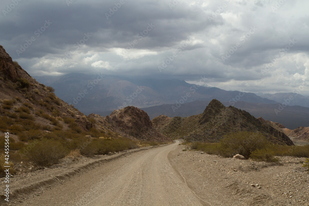 Dirt road into nowhere. Traveling along the desert route in the rocky mountains. Dirt road into nowhere. Traveling along the desert route in the rocky mountains.