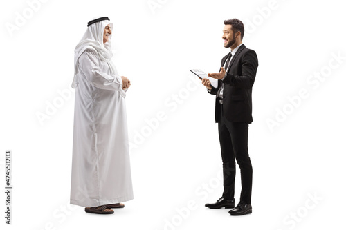 Full length profile shot of a young businessman talking to a mature arab man photo