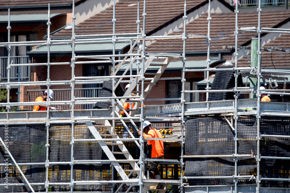 Workers assembling scaffolding on new social housing home unit block at 56-58 Beane St. Gosford, Australia. March 1, 2021. Part of a series. Workers assembling scaffolding on new social housing home unit block at 56-58 Beane St. Gosford, Australia. March 1, 2021. Part of a series.