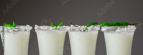 Photos Coconut cocktail in drink shot glass decorated with coconut flakes and green bir
