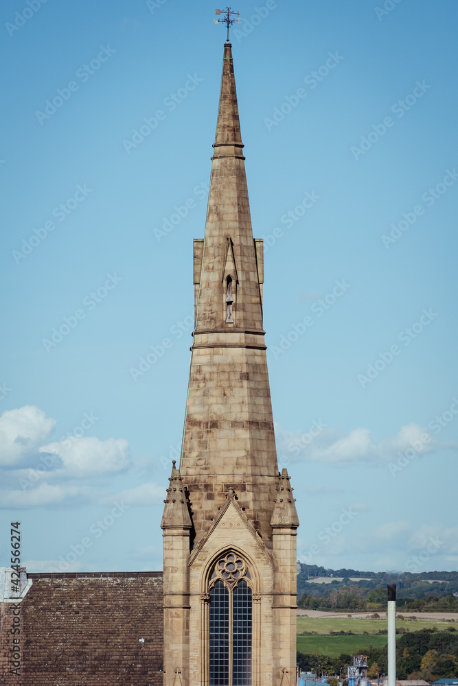 The tower, spire, pointed arch window and ornate gothic architecture of the steeple of the central Rotherham Methodist church