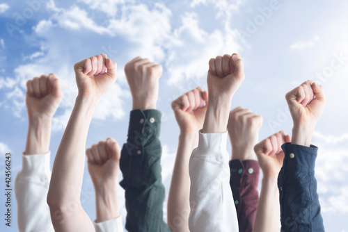 people with raised hands fists in the air, as symbol of protest for equality. freedom.