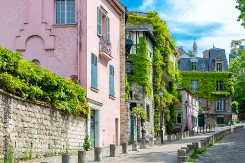 Fototapeta Naklejka Na Ścianę i Meble -  Montmartre in Paris, a very romantic parisian street and houses, with the basilica Sacre-Coeur in background
