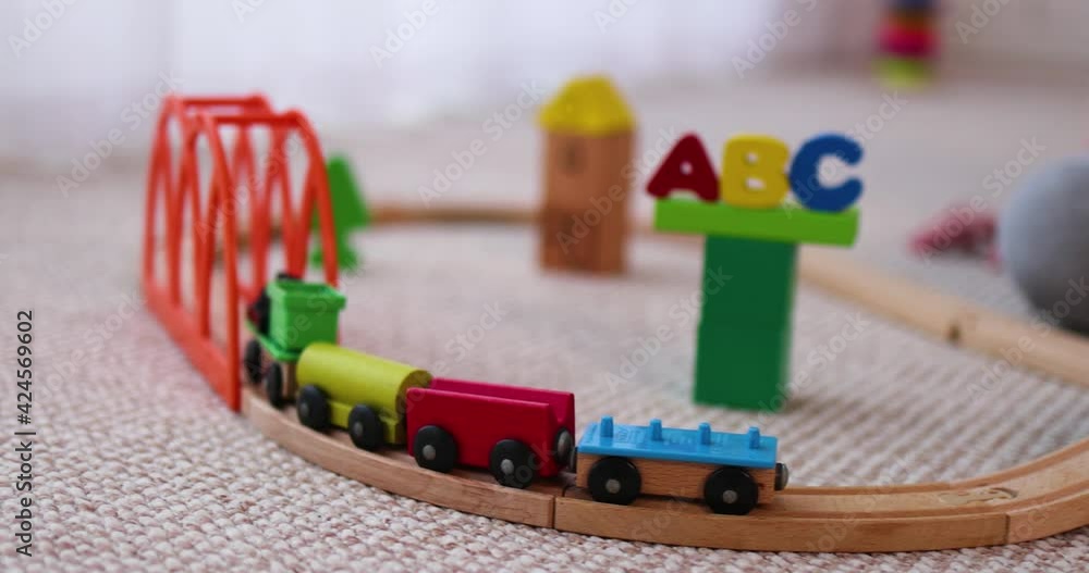 close-up of kid playing a wooden train on railways close-up of kid playing a wooden train on railways