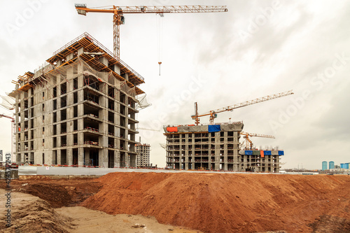 Construction of a monolithic house. Stylobate. Sunny snowy winter day. Construction crane on the background of the sky. Construction site. photo