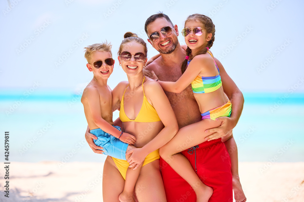 Happy family with kids on ocean shoreline Happy family with kids on ocean shoreline
