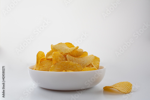 Delicious potato fluted chips lie in a white plate