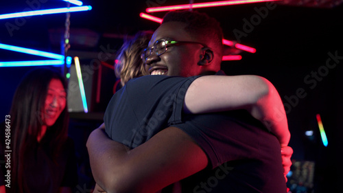 The guys from the team of gamers celebrate the victory, jumping on each other for joy and hugging