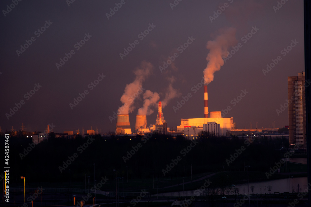 Colorful sunset over the smoking chimneys of the power plant. Southern thermal power plant in St. Petersburg. Air pollution. Ecology problems. The greenhouse effect. Global warming.