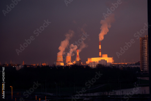 Colorful sunset over the smoking chimneys of the power plant. Southern thermal power plant in St. Petersburg. Air pollution. Ecology problems. The greenhouse effect. Global warming.