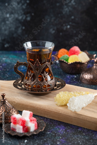 Vertical photo of Hot tea and sweet candies on wooden baord photo