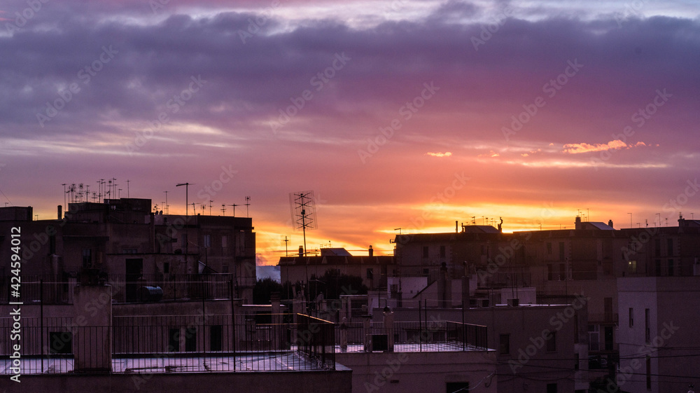 SUNSET RED FIRE WITH SHADES OF MANY COLORS ON THE ROOFS OF HOUSES