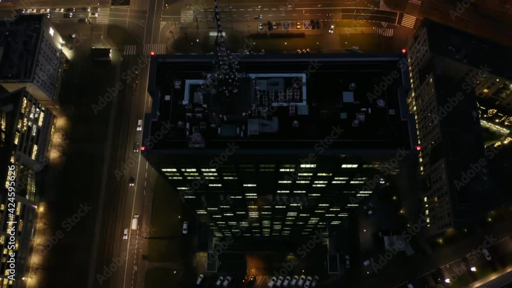 A cinematic shot from a drone at night skyscrapers and megacities at night in the business center of Warsaw, Poland. Drone flight from the roof of a skyscraper at night with a view of office windows A cinematic shot from a drone at night skyscrapers and megacities at night in the business center of Warsaw, Poland. Drone flight from the roof of a skyscraper at night with a view of office windows