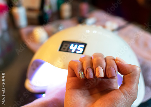 woman in beauty salon having a manicure and gelish. with pink nails photo