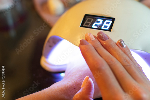 woman in beauty salon having a manicure and gelish. with pink nails photo