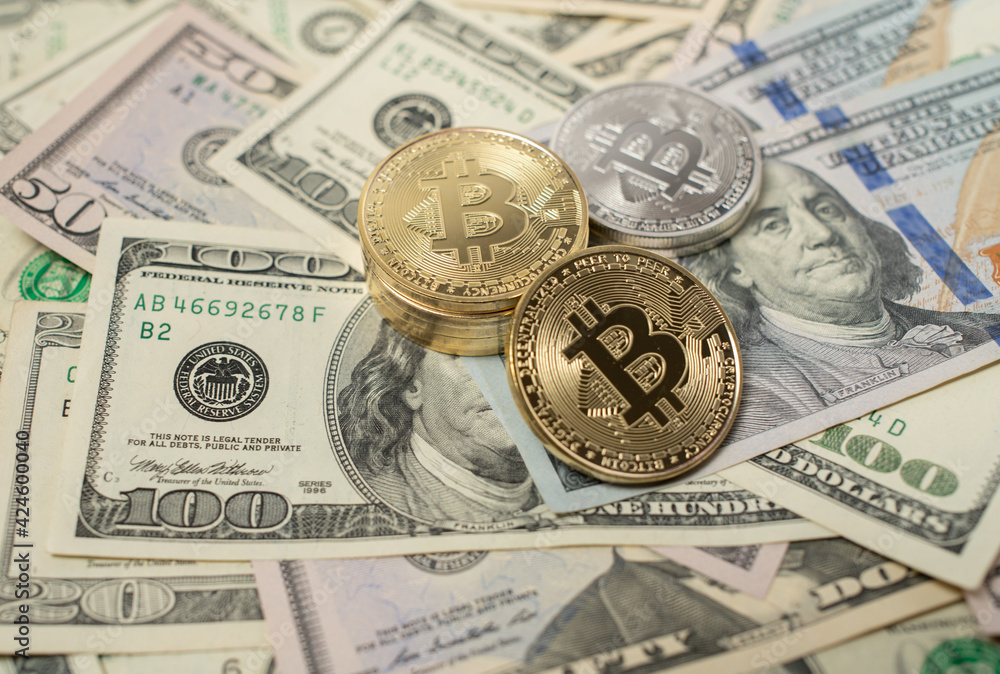 Bitcoin on top of United States Dollar Banknotes. Fiat currency and Cryptocurrency concept. 100 Dollar Bills and 50 Dollar Banknotes with golden and Silver BTC Coins Bitcoin on top of United States Dollar Banknotes. Fiat currency and Cryptocurrency concept. 100 Dollar Bills and 50 Dollar Banknotes with golden and Silver BTC Coins